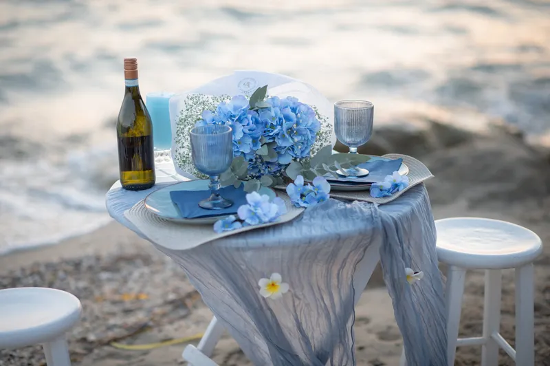 Oceanfront table set for two with wine and flowers