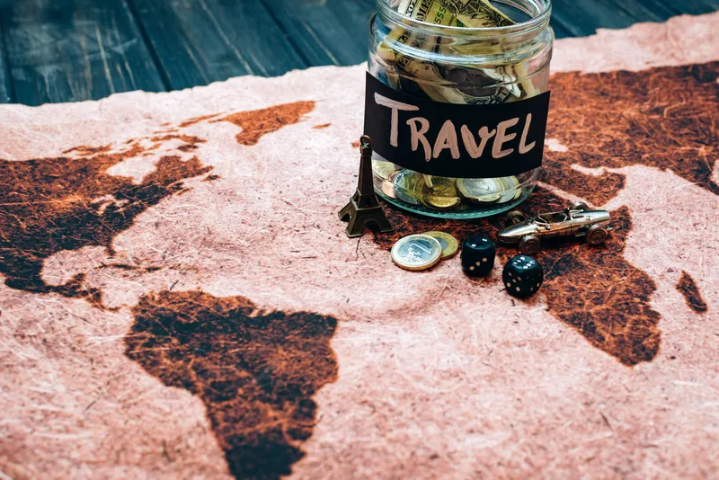 Travel savings jar with coins on a world map